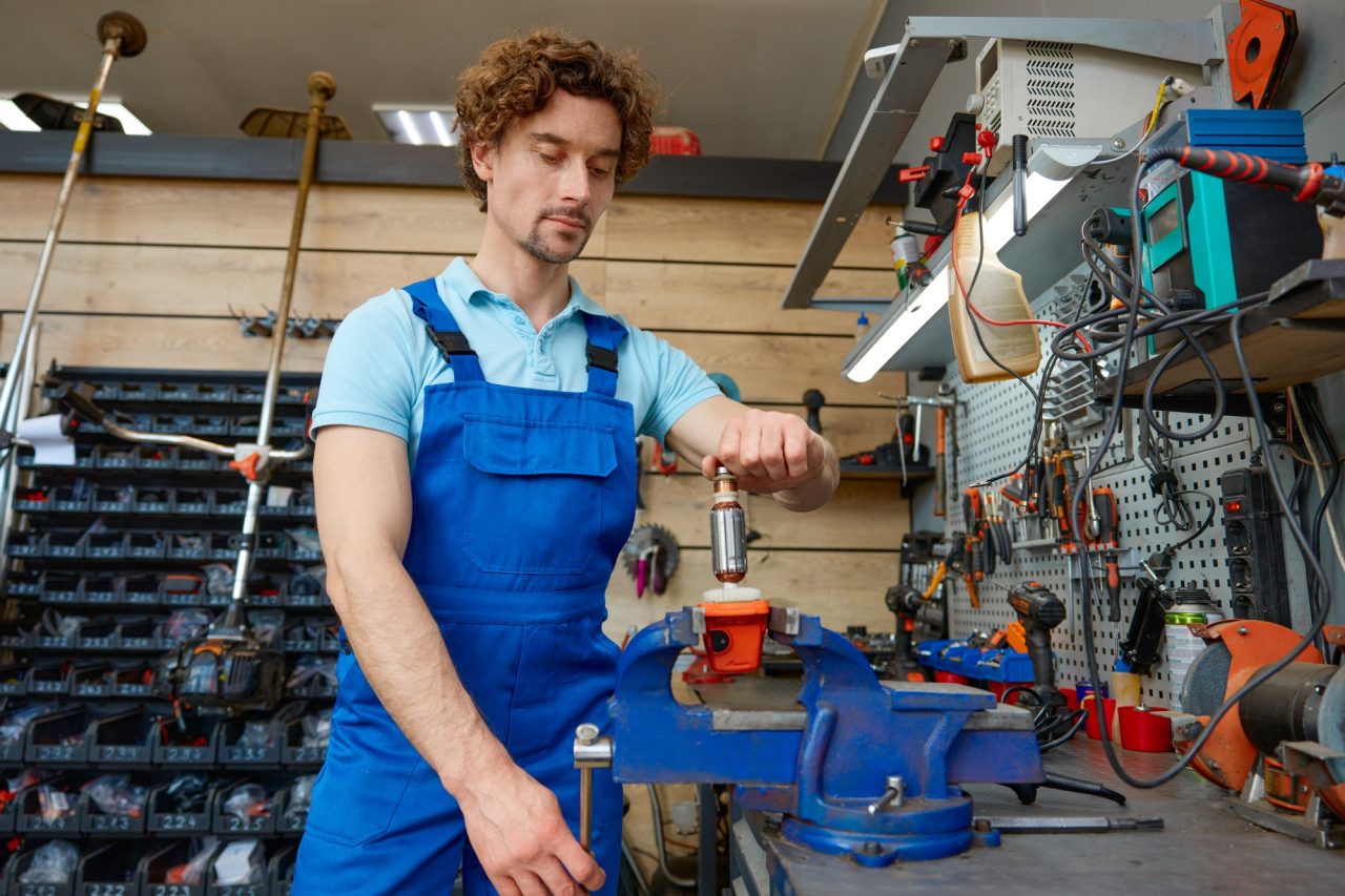 cropped shot of craftsman using antique bench vise in repair shop
