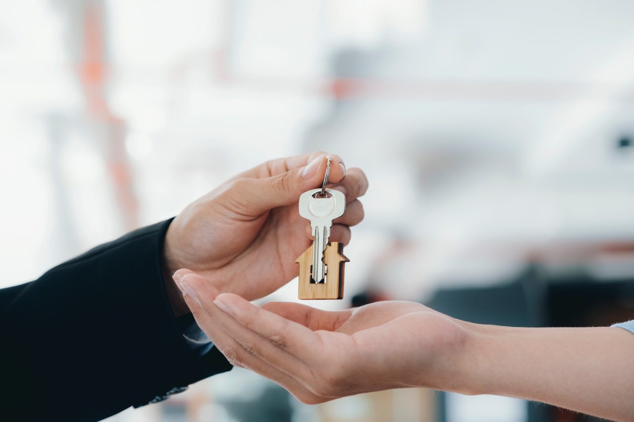 real estate agent holding key with house shaped keychain